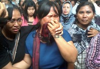 Salah satu anggota keluarga Ibu Martina histeris saat melihat keempat peti jenazah yang dibawa oleh prajurit TNI AU.(Muhammad Nur Abdurrachman/detikcom)