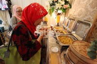 Seorang pengunjung, menikmati stand sajian makanan untuk acara pernikahan pada pameran pernikahan Grand Wedding Expo 2012.