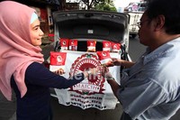 Terlihat seorang pedagang dan pembeli terlihat sedang asyik bertransaksi