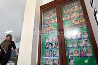 Seorang petugas Panti Sosial Asuhan Anak Balita Tunas Bangsa, melintas di samping bingkai besar foto para anak yang terlantar, yang mendapatkan penaganan dan perawatan.