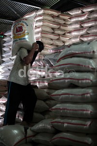 Pekerja melakukan aktivitas bongkor muat beras di Pasar Induk Cipinang, Jakarta.