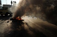Dalam aksinya mahasiswa UMI memblokir jalan depan kampusnya dengan menyandera sebuah mobil box yang dicegat di tengah jalan serta membakar ban bekas. Muhammad Nur Abdurrahman/detikcom.