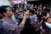 Jokowi dengan gaya khasnya mempromosikan kartu sehat dan kartu pintar.