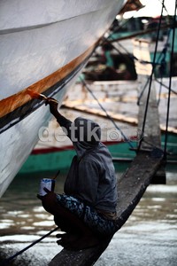 Seorang pekerja melakukan pengecetan ulang kapal Pinisi yang bersandar di Pelabuhan Sunda Kelapa, Jakarta.