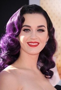 Katy memoles bibirnya dengan liptstick yang senada dengan dressnya. (Getty Images/Kevin Winter)