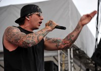 Topi dibalik dan kacamata hitam jadi ciri khas penampilan M Shadows. Getty Images/Theo Wargo.