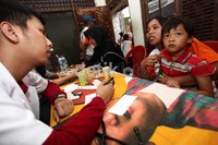 Petugas medis dari Denta Medika menayakan keluhan kesehatan warga.