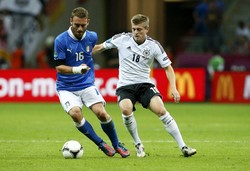 Toni Kroos melakukan pengawalan ketat terhadap Daniele De Rossi. Reuters/Tony Gentile.