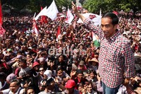 Jokowi melakukan salam metal kepada para pendukungnya.
