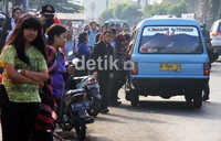 Puluhan penumpang berebut naik angkutan umum di kawasan Kampung Melayu.