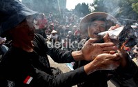 Seorang demonstran menghisap rokok raksasa.
