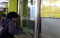 Seorang calon penumpang terlihat sedang bertransaksi di loket resmi penjualan tiket kereta api Stasiun Gambir.