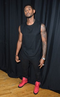 Usher tampil santai dengan kaos hitam tanpa lengan dan celana hitam yang disentuh dengan sepatu berwarna shocking pink. Alberto E. Rodriguez/Getty Images.
