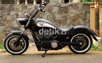 Desain mesin V-Twin juga terasa serasi di bagian tengah motor dengan dua knalpot yang menyembur kencang serta ban gambot beraksen putih yang membalut pelek jari-jari, membuat desainnya tidak lekang dimakan zaman. Syubhan Akib/detikOto.