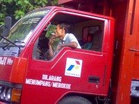 Foto di daerah Pangandaran, Jawa Barat. Petugas elpiji tersebut mengangkat tabung gas 3 kg dengan rokok menyala di tangannya. (Hari Bahagia)