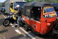 Pengendara motor mencoba keluar dari kemacetan dengan naik ke trotoar.