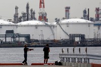 Pemancing melempar kail di dekat kilanng minyak di Kawasaki Jepang. Mulai Juli ini, Jepang menyetop minyak Iran masuk ke negeri matahari terbit tersebut.