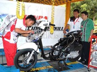 Senior Manager Technical Training Departement PT Astra Honda Motor (AHM), Handy Hariko memeriksa salah satu peserta kontes keterampilan teknis untuk siswa SMK tingkat Nasional di Astra Honda Training Center (AHTC). (Luthfi/detikOto).