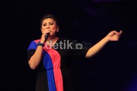 Regina bernyanyi di hadapan pengunjung.