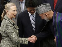Presiden Afghanistan Hamid Karzai (kanan) bersalaman dengan Menlu AS Hillary Clinton disaksikan Menlu Jepang  Koichiro Gemba (tengah). Saat memberi bantuan, lembaga donor mensyaratkan reformasi dan pemberantasan korupsi di Afganistan.  (REUTERS/Kim Kyung-Hoon)