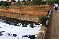 Warga melintas di atas jembatan BKT yang telah telah tercemar oleh limbah industri dan sampah masyarakat sekitar.