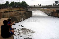 Dua anak memandang air di Banjir Kanal Timur yang telah tercemar oleh limbah rumah tangga.