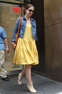 Dibalut dress kuning dan jaket jeans, Katie Holmes terlihat meninggalkan kantor pengacaranya di New York pada Sabtu (7/7/2012). Mehdi Taamallah/AFP.