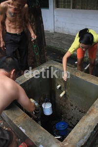 Warga mengambil air dari penampungan air yang sudah mulai surut.