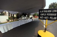 Di bawah tenda tersebut hanya terdapat jejeran meja panjang yang dilapisi kain putih.