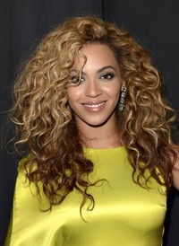 Rambut keriting bernuansa coklat memang menjadi ciri khas Beyonce Knowles. Jason Merritt/Getty Images.