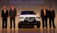 (Ki-ka) Executive Vice President Mitsubishi Motor Corporation Gayu Uesugi, President Director Noboru Tsuji PT Krama Yudha Tiga Berlian Motors bersama staf berpose di depan mobil Mitrsubshi Outlander Sport.