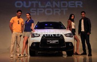Model berpose di depan Mitrsubshi Outlander Sport.