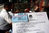 Seorang petugas menunjukan kartu pemilih atas nama Angelina  Sondakh yang mempunyai hak pilih di TPS 030 Komplek Perumahan Cilandak, Jakarta Selatan, Rabu (11/7/2012). (Ramses/detikcom)