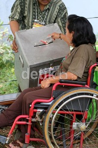 Seorang penyandang cacat memasukkan surat suara ke kotak suara. Ramses/detikcom.