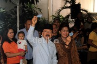 Foke dan istri menunjukkan kartu pemilih tetap.