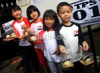 Cucu Foke menunjukkan kue berlogo kumis.