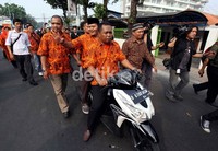 Hidayat melambaikan tangan kepada warga Kemang saat menaiki kendaraan motor menuju TPS 13. Meski kakinya keseleo, namun ia tetap menggunakan hak suaranya.