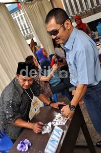 Usai nyoblos, Bambang mencelupkan jari kelingkingnya ke tinta.