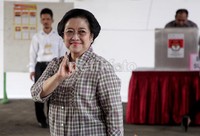 Mega menunjukkan jari kelingking yang telah dicelupkan ke tinta.