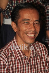 Jokowi tersenyum melihat hasil survei di televisi.