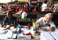 Petugas melayani warga yang akan melakukan pencoblosan.