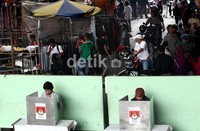 Dua orang warga melakukan pencoblosan.