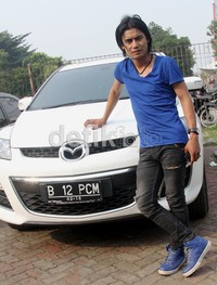 Dengan kaos dan sepatu birnya, Charly berpose di depan mobil kesayangannya. Gusmun/detikHot.