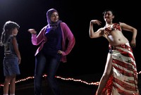 Seorang perempuan berjilbab menirukan bagian adegan tari perut. Tari inimenjadi tradisi turun temurun di sebagian besar negeri Timur Tengah. (REUTERS/Amr Abdallah Dalsh)