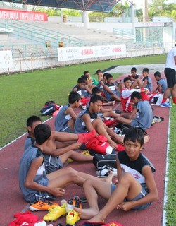 Bersiap-siap ganti kostum dengan jersey latihan warna abu-abu berlogo Garuda di dada, khas tim nasional Indonesia.