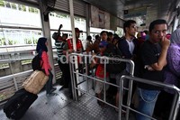 Penumpang harus antre panjang sebelum bisa naik ke dalam bus.