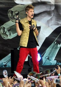 Penampilan Justin Bieber di acara MTV World Stage 2012 yang digelar di Kuala Lumpur, Malaysia pada Sabtu (14/7/2012) dibalut dengan kaos hitam, vest krem, dan celana merah. AFP/Mohd Rasfan.