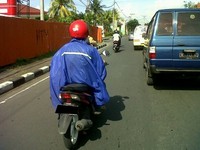Ini salah satu pengendara sepeda motor yang memakai jas hujan saat hari sedang cerah dan sangat panas. Dipotret di Denpasar, Bali (Foto Anasi Raga)