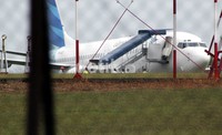 Beberapa petugas tengah melakukan evakuasi. Diduga, licinnya runway jadi penyebab insiden ini. Beberapa saat sebelum kejadian, hujan deras mengguyur Pekanbaru. (Chaidir Anwar Tanjung/detikNews).