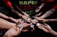 Para buruh mengumpulkan koin untuk dilemparkan ke Gedung BUMN. Mereka mengecam Menteri BUMN Dahlan Iskan yang membiarkan Pertamina menerapkan outsoursing. Menurut para buruh, BUMN sudah dilarang menggunakan tenaga kontrak.